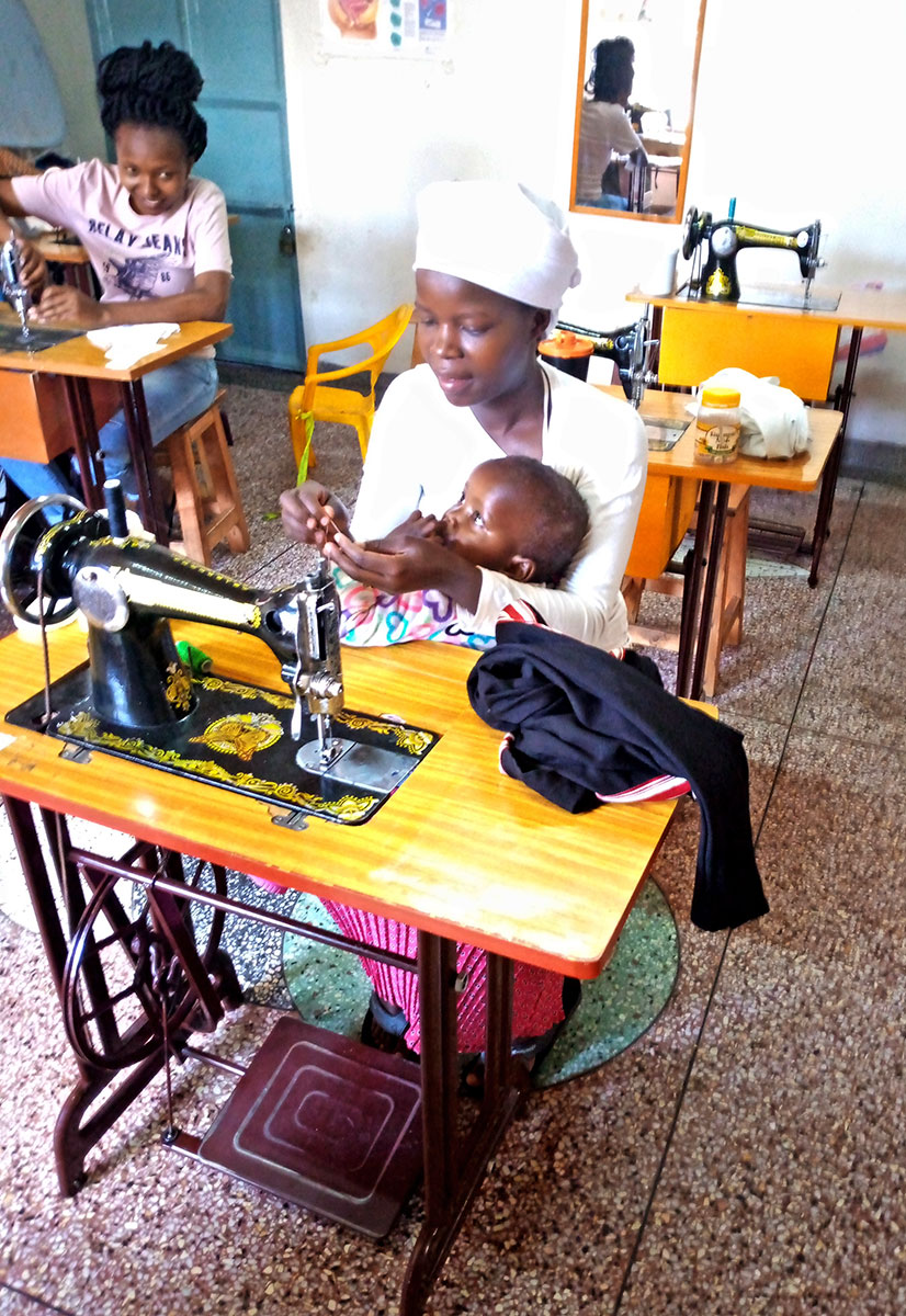 Teen girls with baby sewing